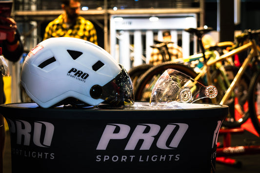 Witte Pro Sport Lights-fietshelm met donker vizier en een los helder vizier op de presentatietafel